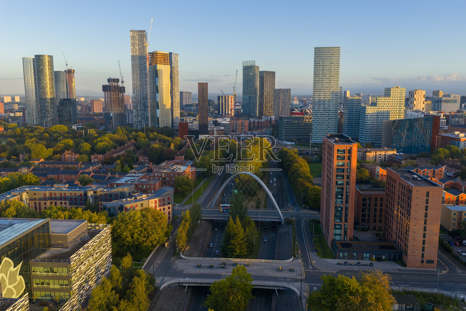从空中俯瞰公主路,曼彻斯特的天际线在金色的晨光中闪耀。照片摄影图片
