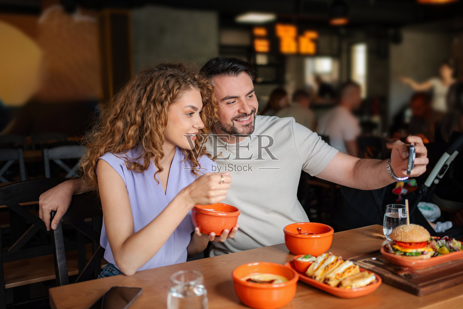 年轻情侣在餐厅用餐时自拍照片摄影图片
