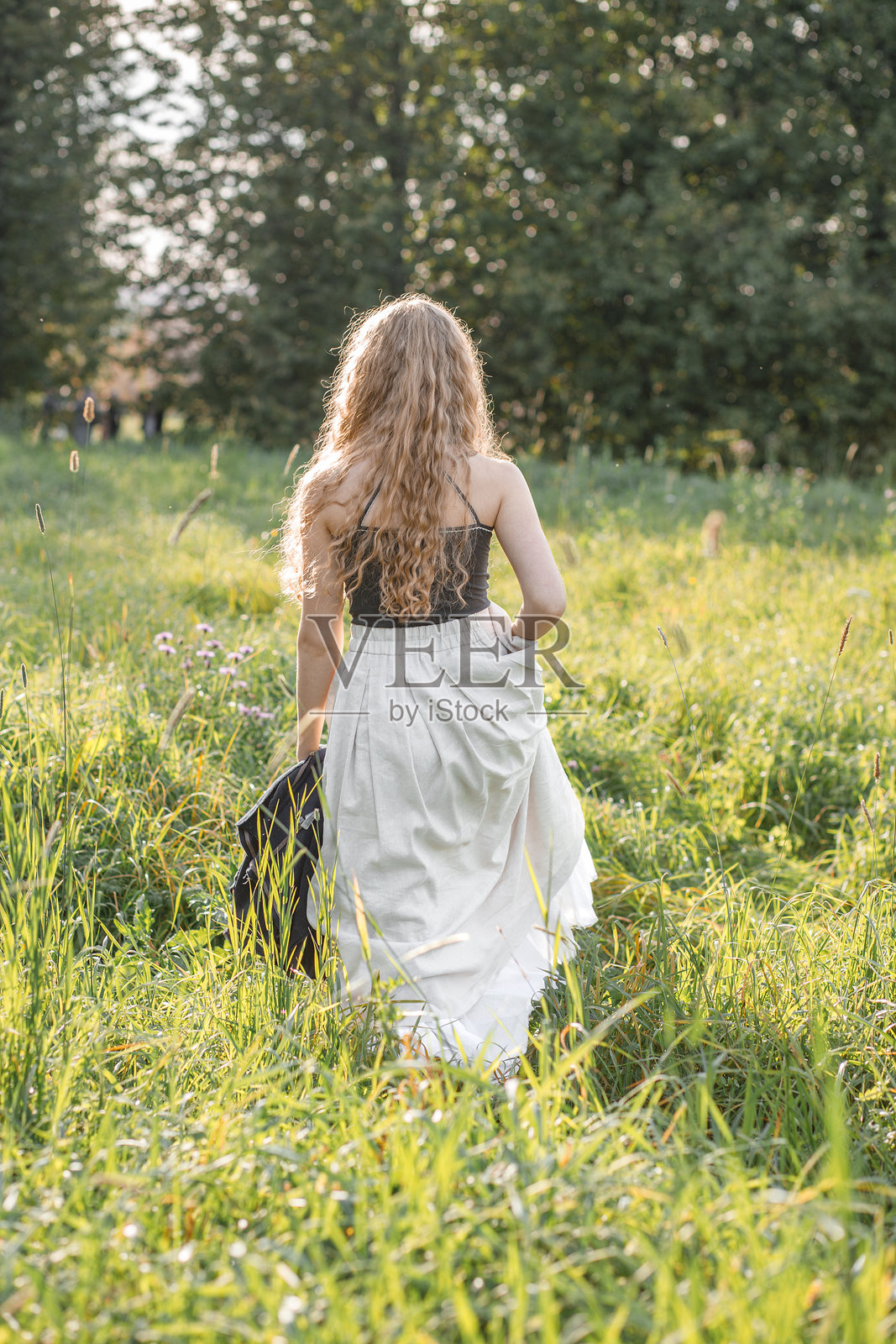 夕阳下年轻嬉皮士女性的时尚肖像,在大自然背景下摆姿势照片摄影图片