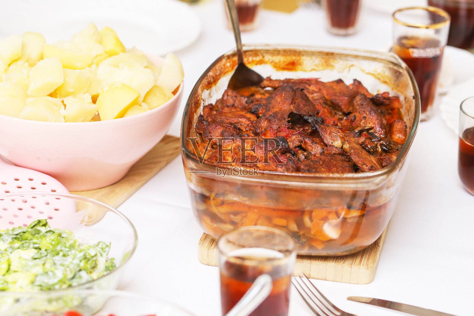 烤肉配酱汁盛于玻璃盘中。传统家常晚餐摆放在桌上。照片摄影图片