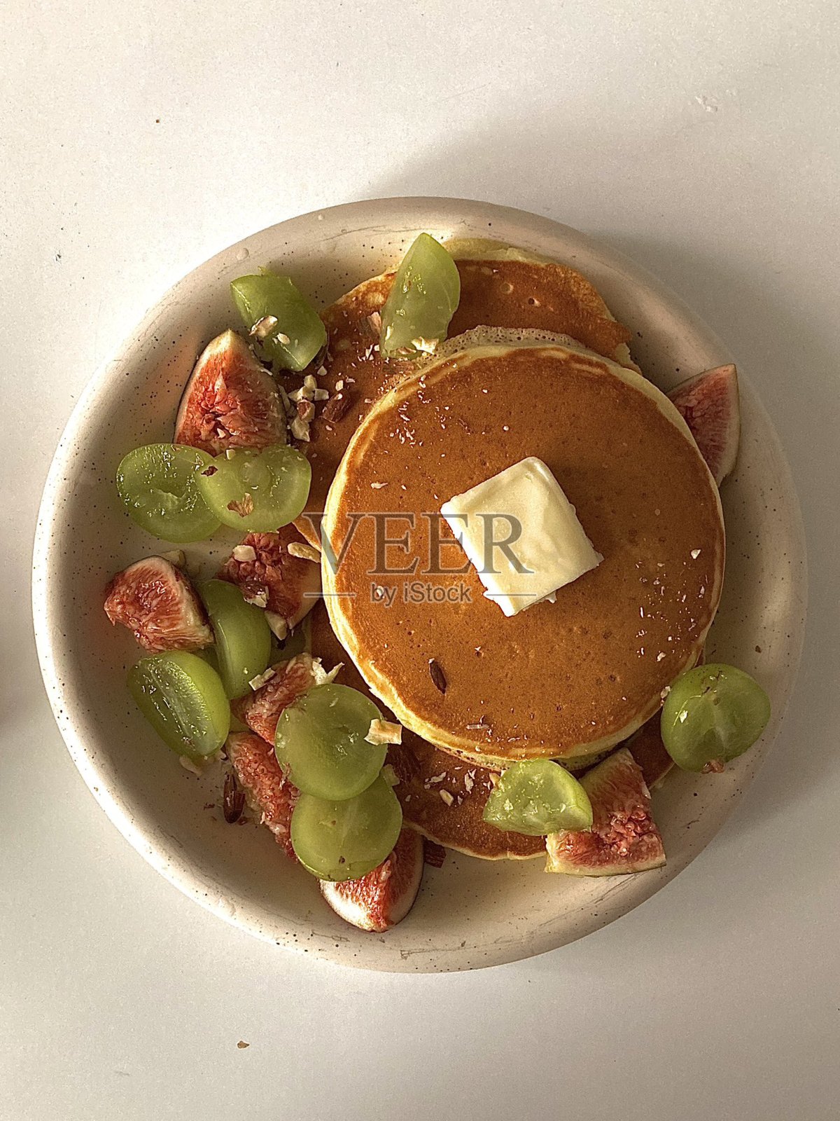 蓬松金黄的煎饼堆叠在一起,配上糖浆、黄油或新鲜水果。这款早餐经典温暖而令人满足,口感柔软香甜,完美契合您的味蕾。照片摄影图片