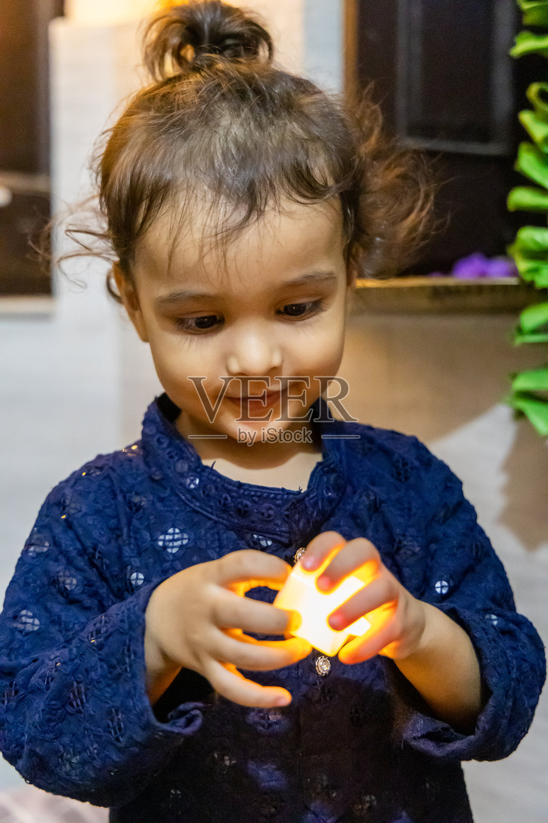 可爱的小孩在印度排灯节期间,手里拿着电子蜡烛,显得非常兴奋。照片摄影图片