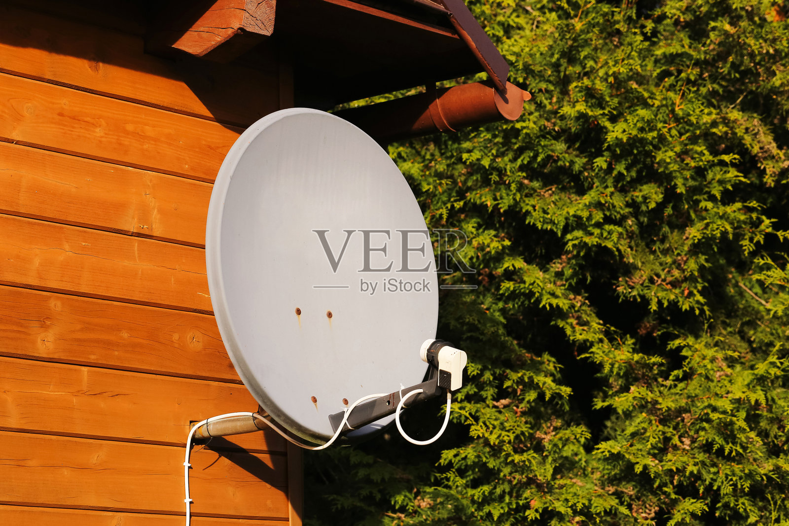 木屋墙上的卫星天线。户外的通信技术设备。电视信号接收器天线特写。照片摄影图片
