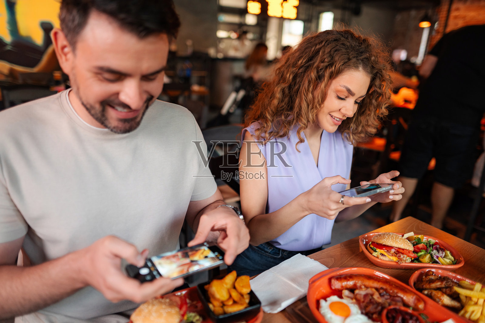 年轻情侣在餐厅拍照美食照片摄影图片