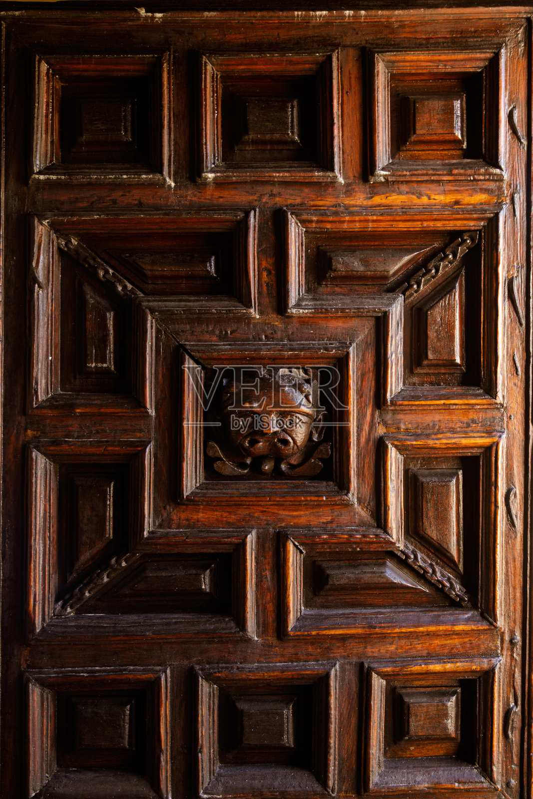 墨西哥瓜纳华托市圣母大教堂(Basilica of Our Lady of Guanajuato)雕刻着几何图案和人脸浮雕的木门特写照片摄影图片