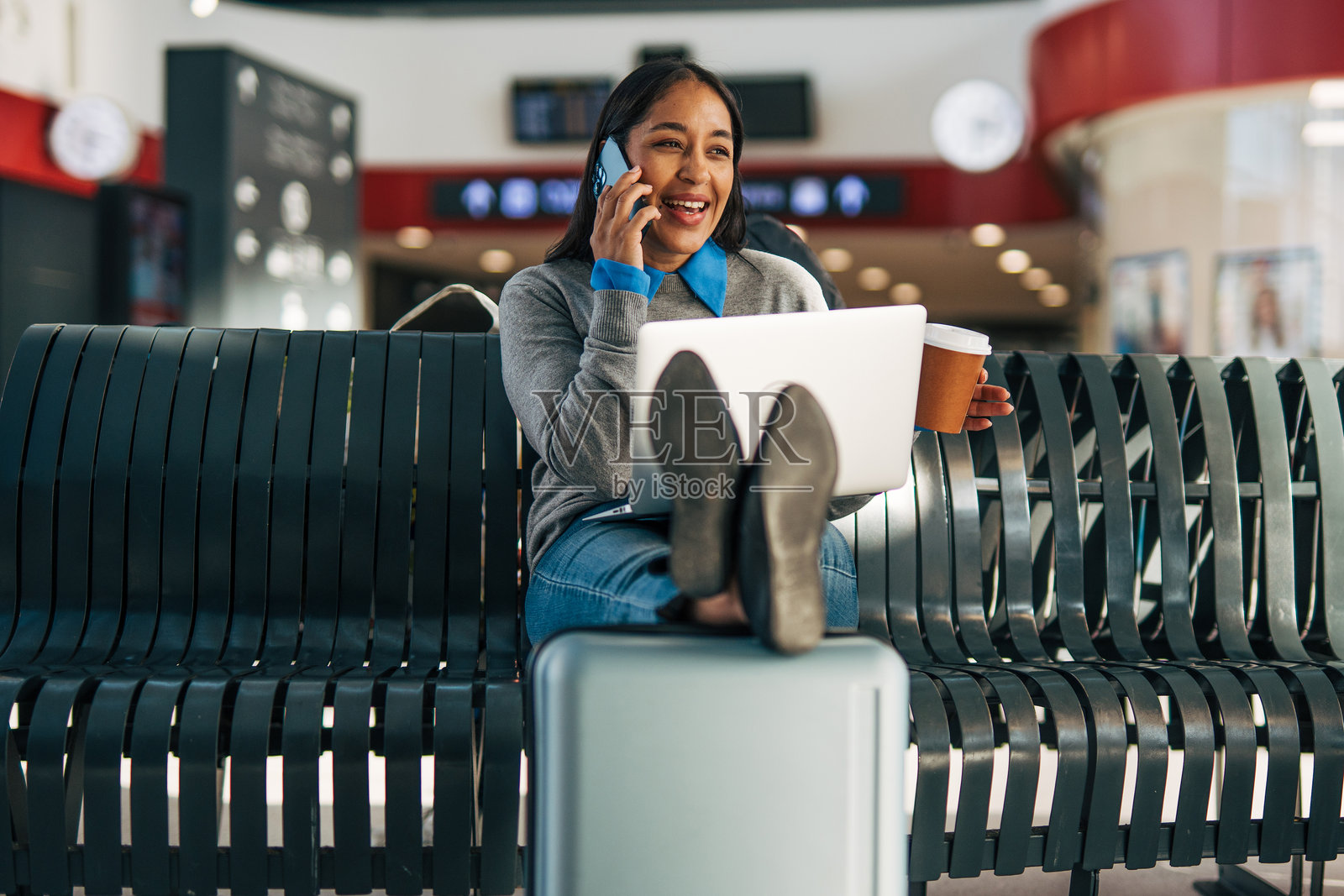 一位女士在机场一边打电话一边远程工作照片摄影图片