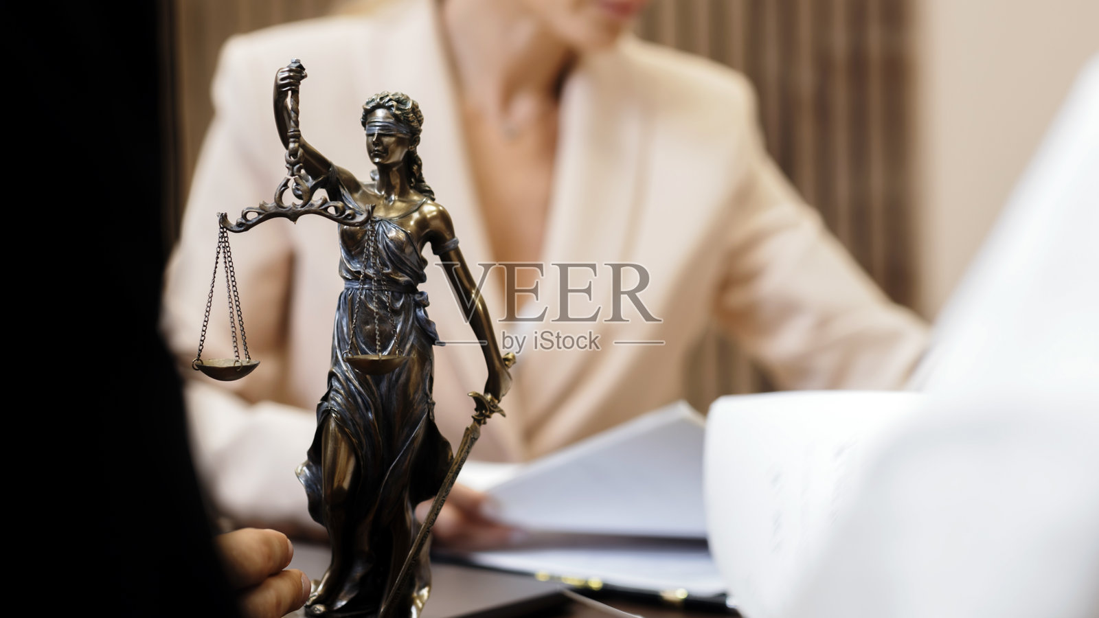 一对已婚夫妇与一位律师在现代办公室的桌边讨论家庭法律事务。照片摄影图片