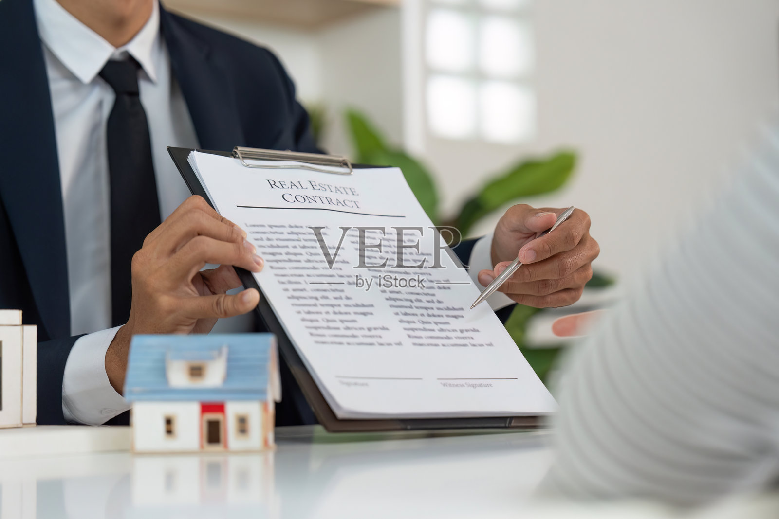 房产经纪人向客户展示购房合同照片摄影图片