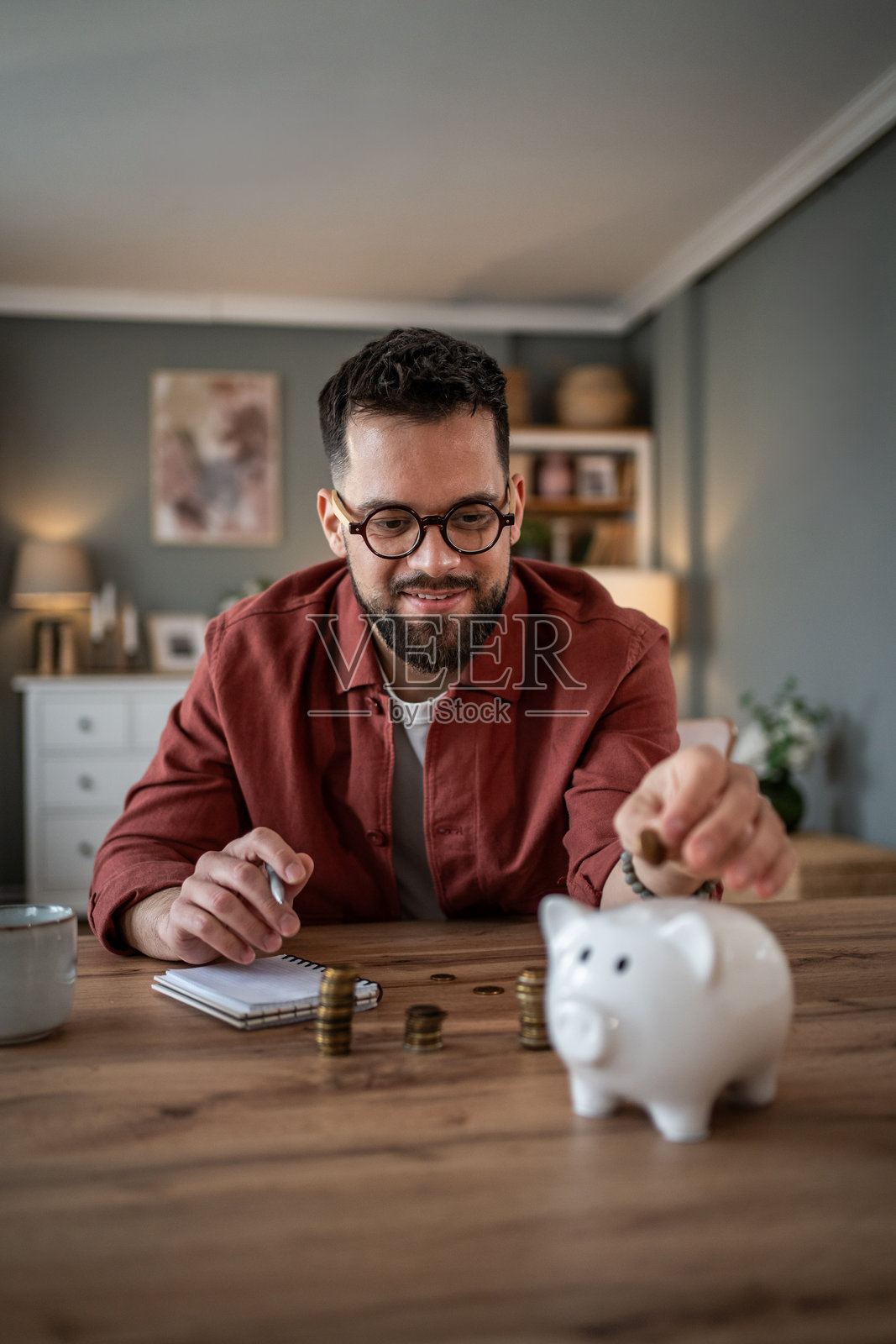 男人将钱存入储蓄罐以备未来财务照片摄影图片