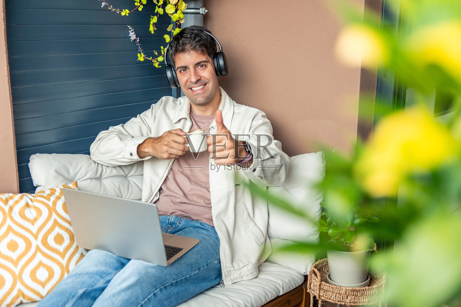 年轻男子在家远程办公,竖起大拇指照片摄影图片