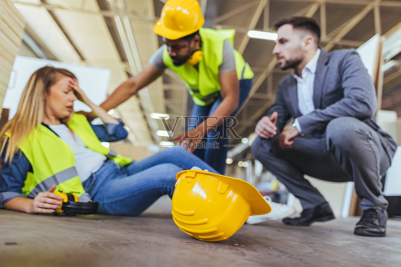 建筑工地上工人帮助受伤同事的事故场景照片摄影图片