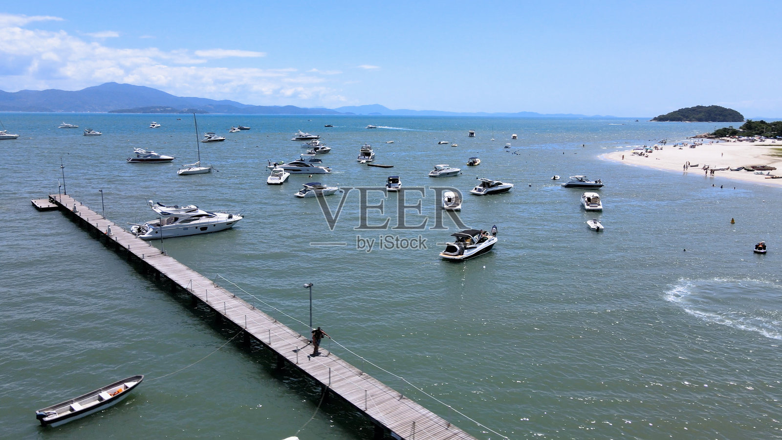 从空中俯瞰弗洛里亚诺波利斯圣卡塔琳娜州的胡雷雷国际海滩和卡纳茹雷海滩,碧绿的海面上点缀着船只、游艇和帆船,还有着码头和栈桥。照片摄影图片