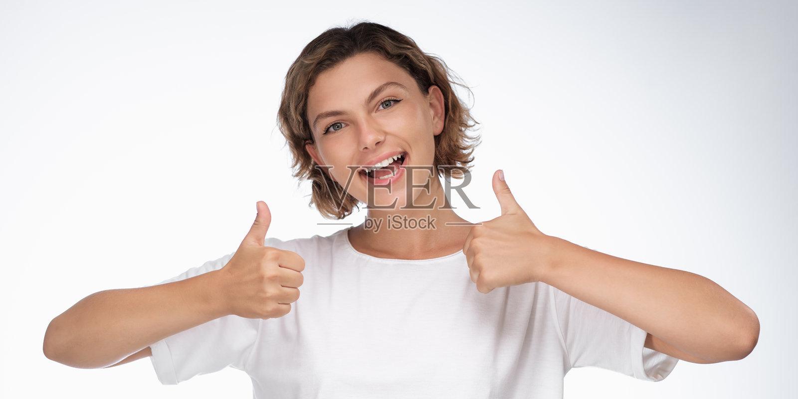穿着白色T恤的兴奋女子竖起两个大拇指,用于横幅广告照片摄影图片