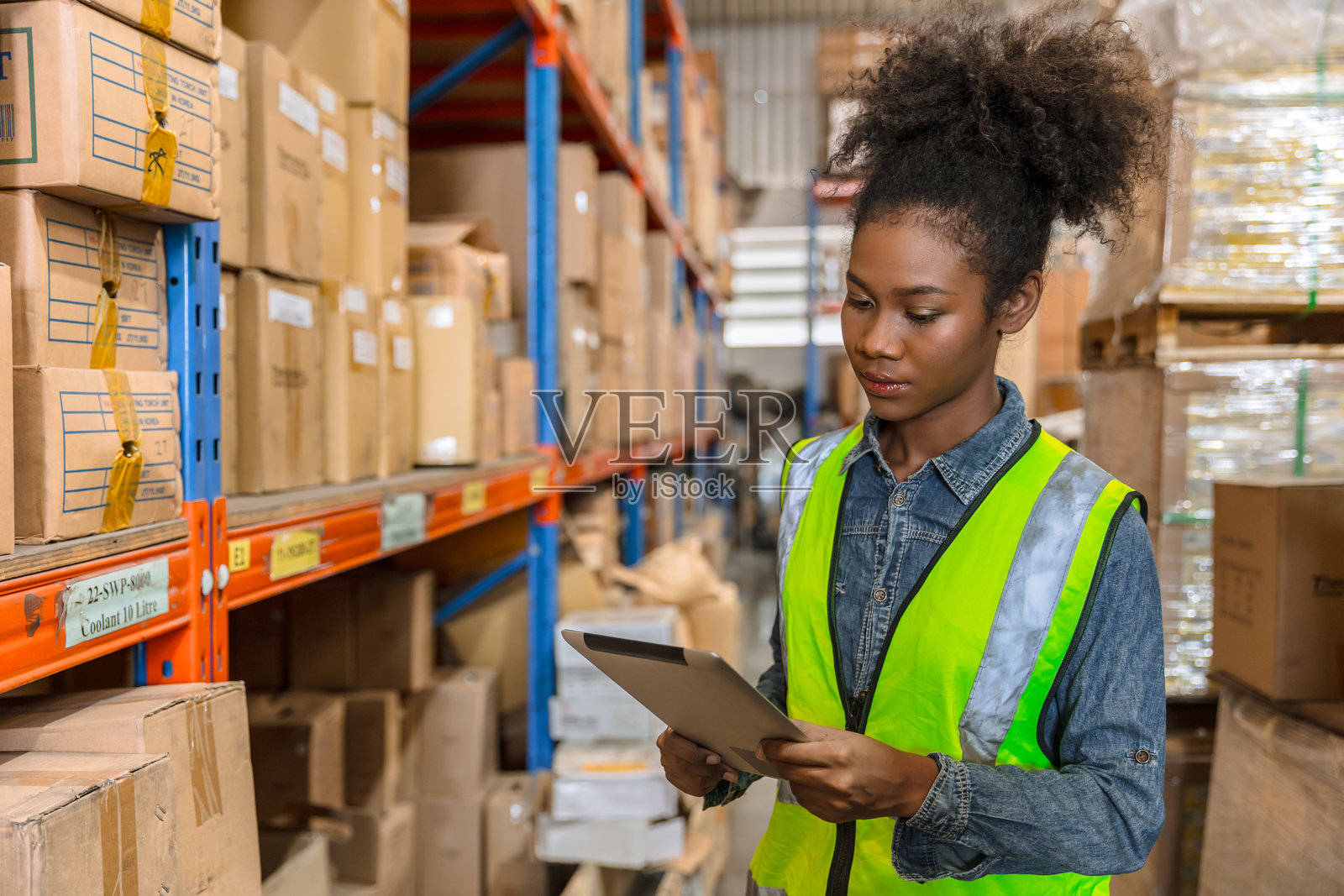 非洲的年轻聪明黑人工作人员在货运仓库盘点,是一名员工,手持平板电脑。照片摄影图片