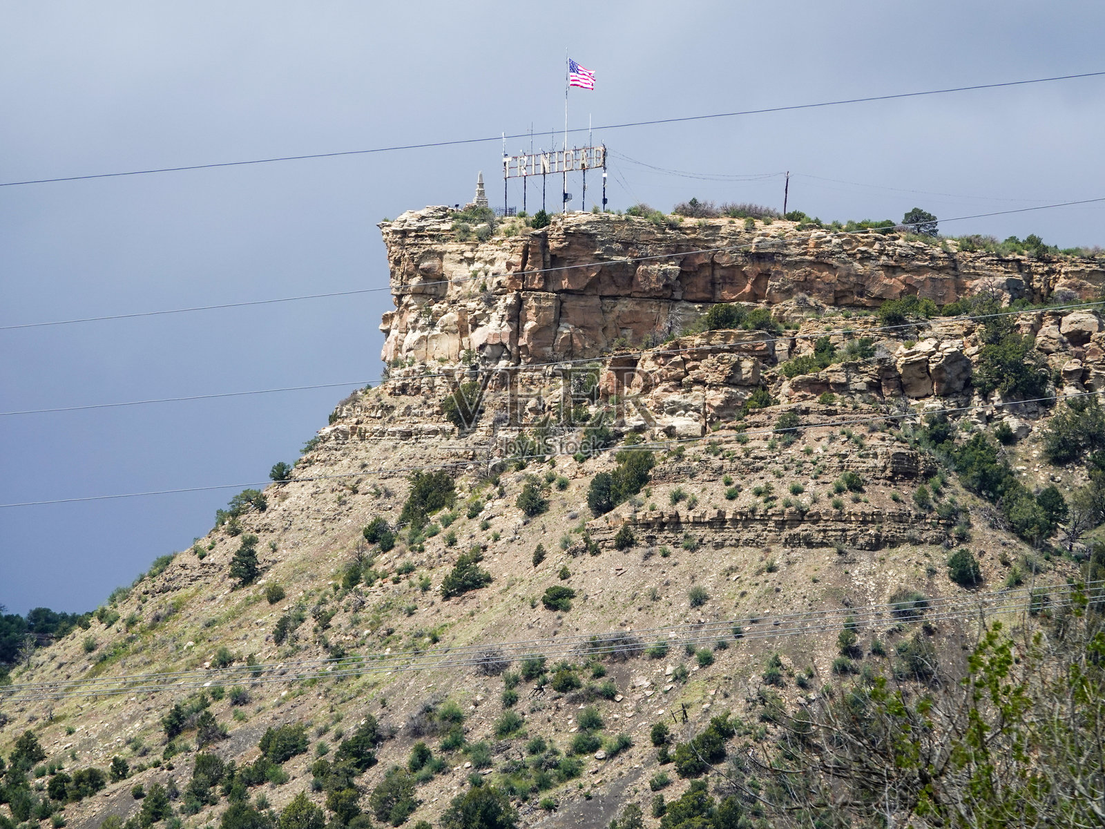 科罗拉多州特立尼达市上方高台上的美国国旗和城市标志照片摄影图片