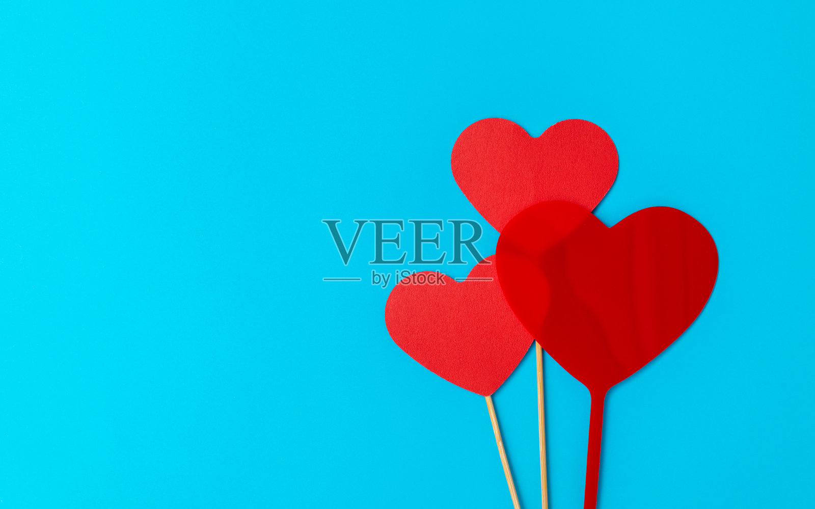 三根棍子上的三个红色心形照片摄影图片