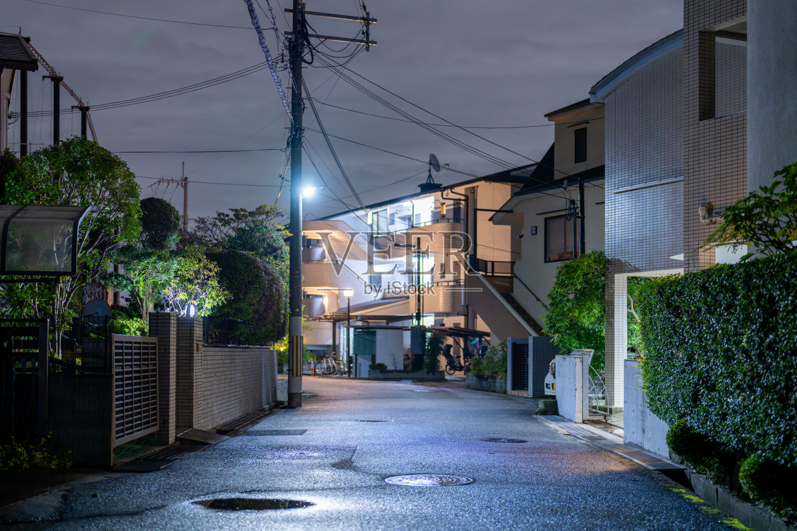 夜晚宁静的居民小巷——雨水浸湿的街道与倒影照片摄影图片