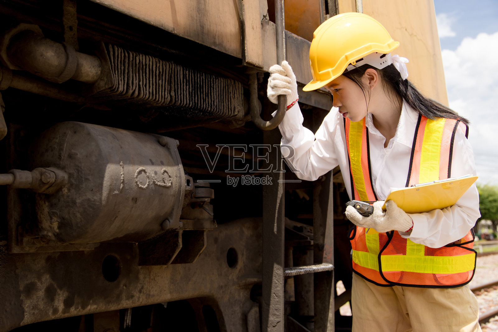 亚洲年轻的青少年工程师在火车站工作,对旧火车头进行维护保养照片摄影图片