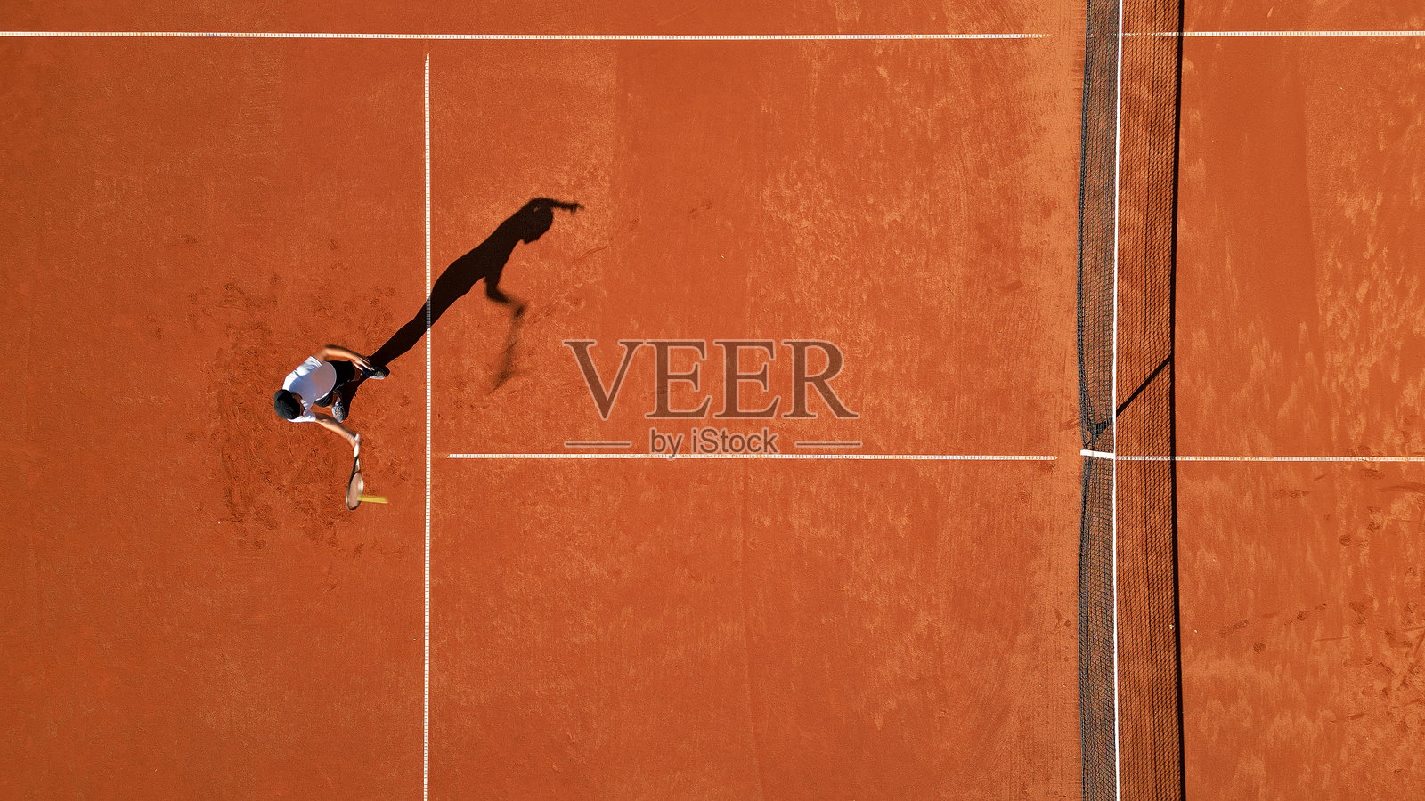 网球运动员在红土球场上挥拍瞬间照片摄影图片