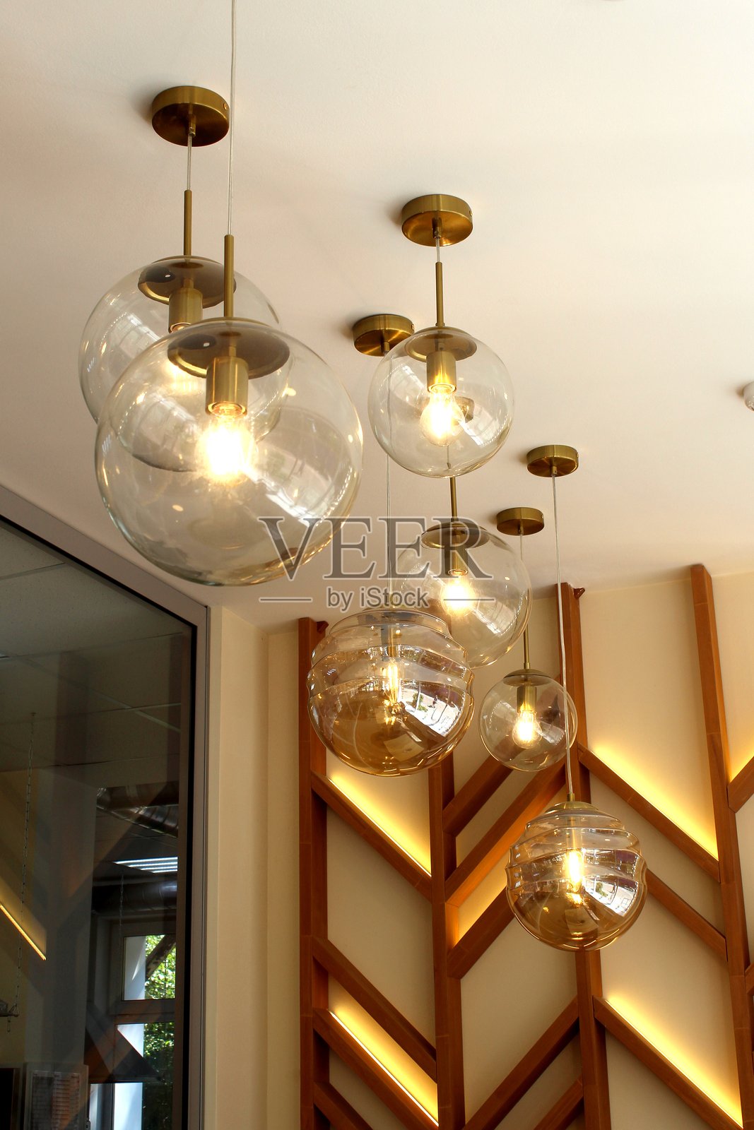 圆形的玻璃灯从天花板上垂下。照片摄影图片