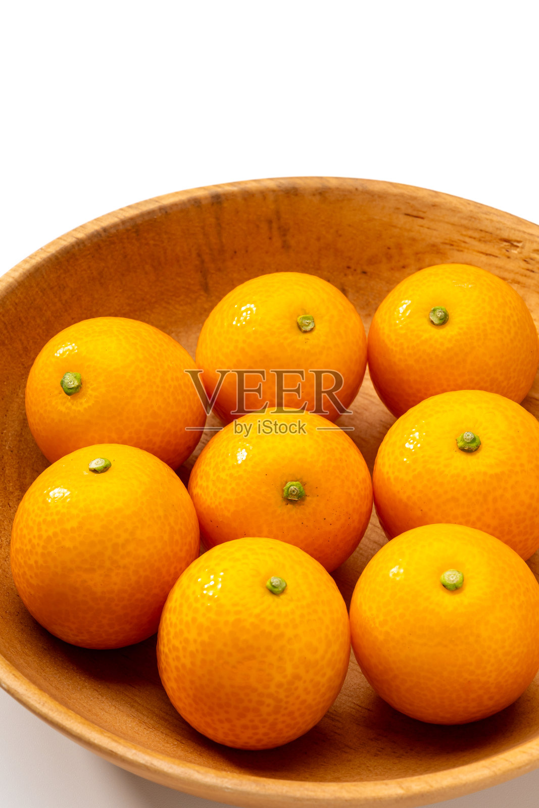 白色背景上木碗里的新鲜金桔照片摄影图片