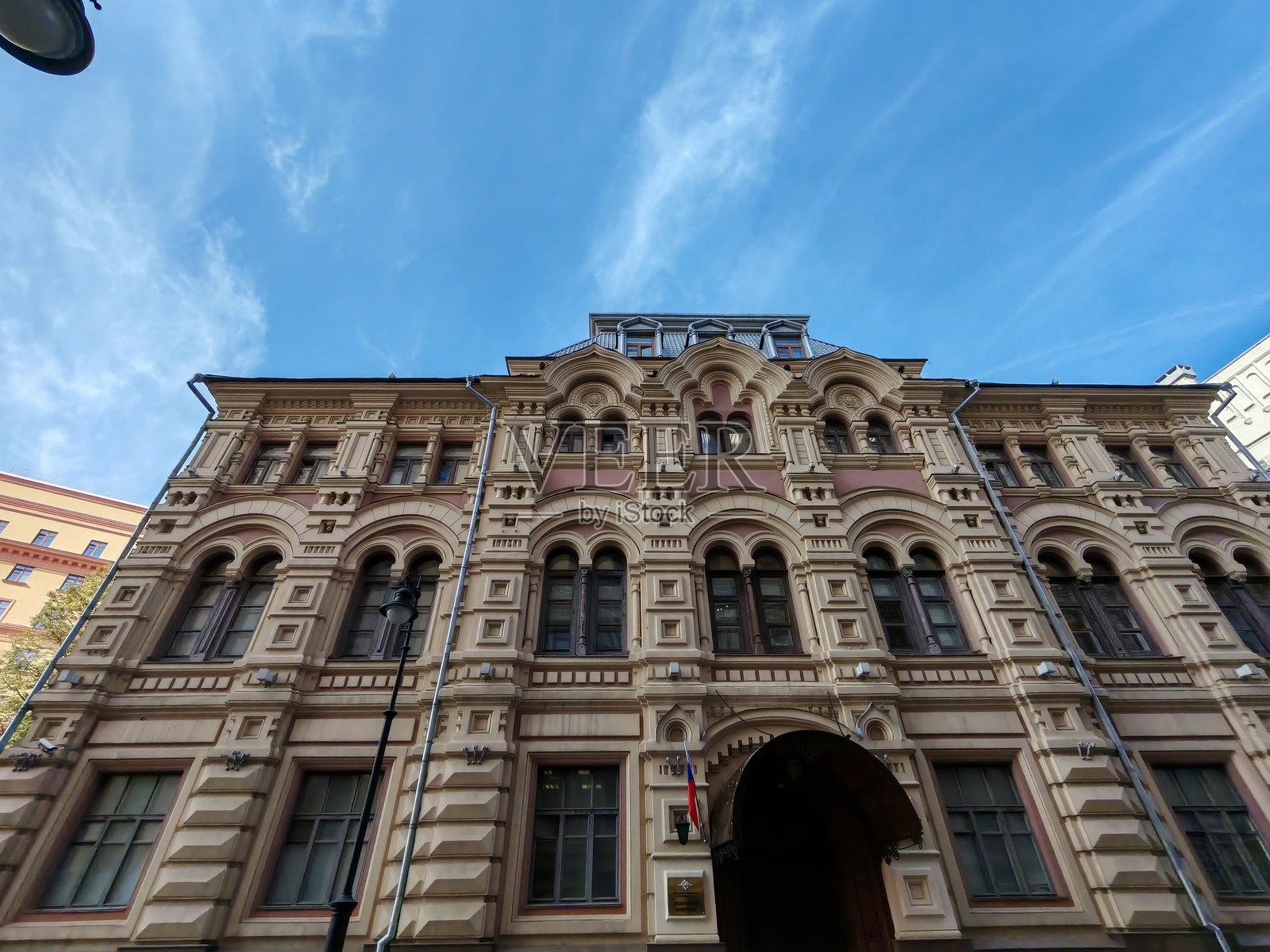 一栋经典的红白米色砖砌外墙、一排排抛光窗户的多层建筑。这些建筑常常象征着城市中心稳定、神秘和不为人知的秘密。照片摄影图片