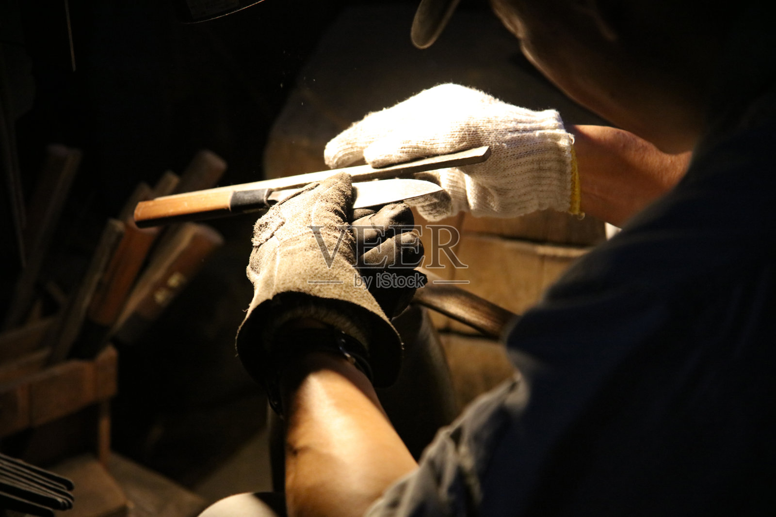 一位工匠正在仔细地打磨刀具照片摄影图片