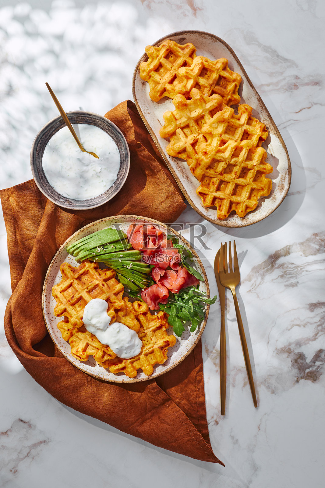 丰盛的红薯或南瓜华夫饼,配牛油果、三文鱼、芝麻菜和酱汁照片摄影图片