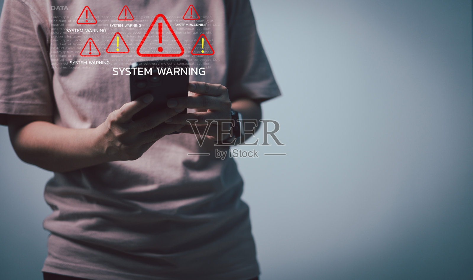 一个人拿着一部智能手机,上面显示着数字系统警告提示,象征着网络安全风险、数据泄露、病毒攻击以及在现代数字技术世界中移动设备的安全问题照片摄影图片