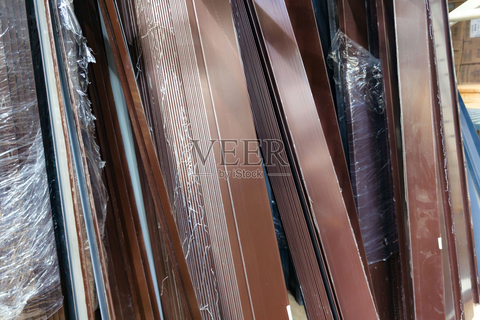 在城市地区,棕色的金属条堆叠在建筑工地,等待在白天安装。照片摄影图片