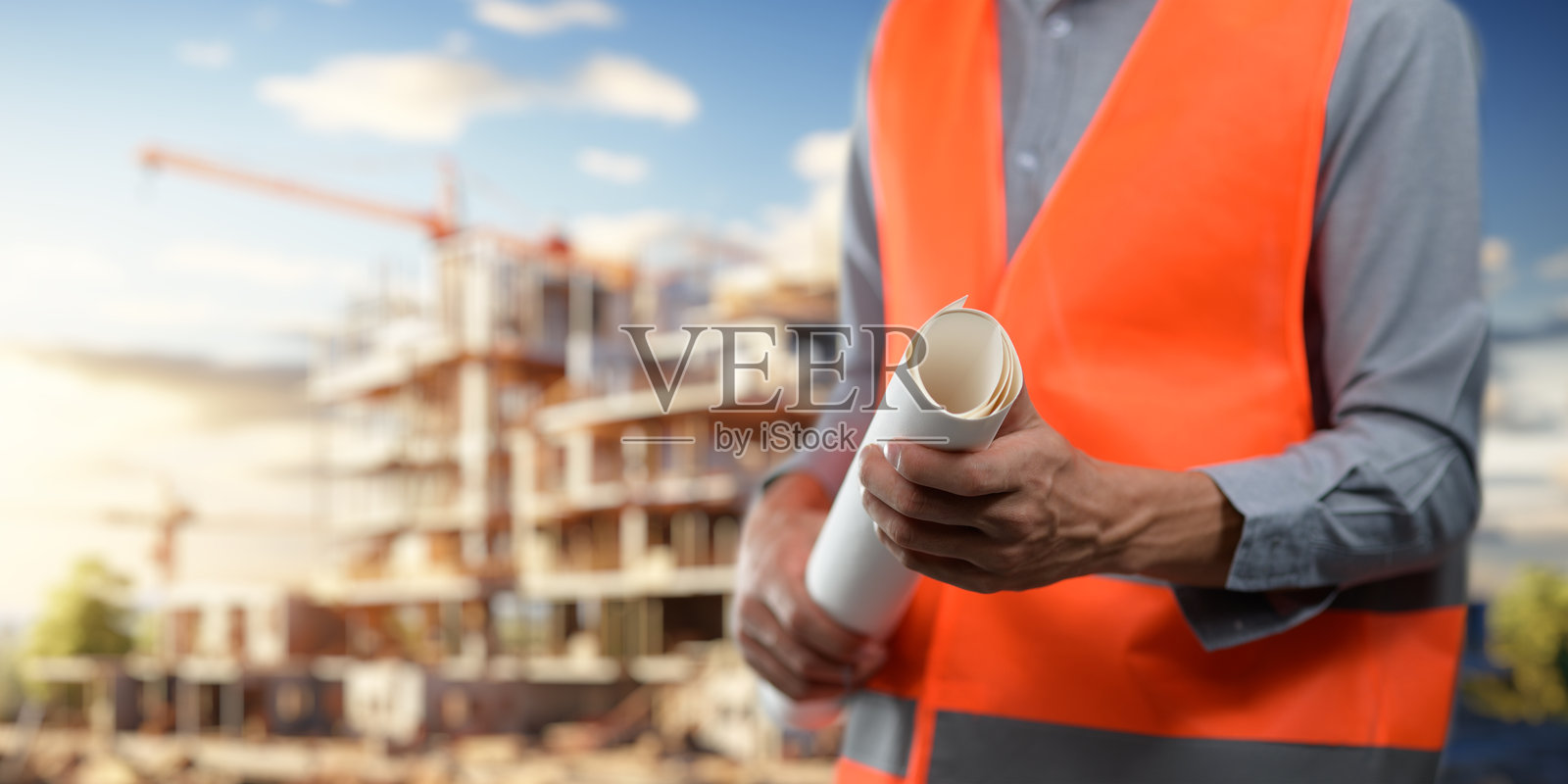 工程师手持建筑蓝图模板,正在检查房屋建筑的准确性照片摄影图片