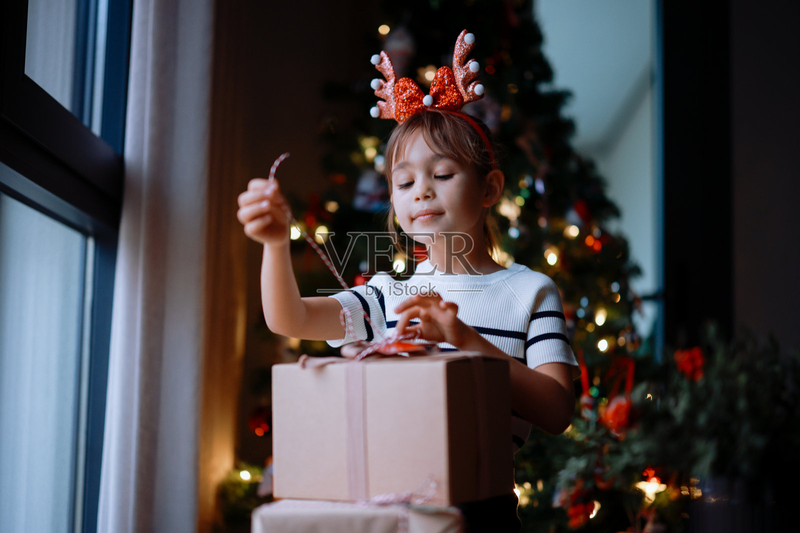 快乐的小女孩在圣诞树旁早晨收到礼物照片摄影图片