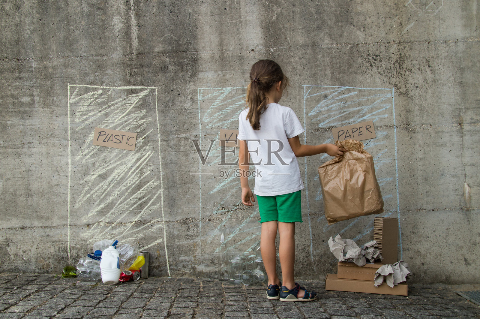 孩子在回收站分拣纸板和纸张照片摄影图片