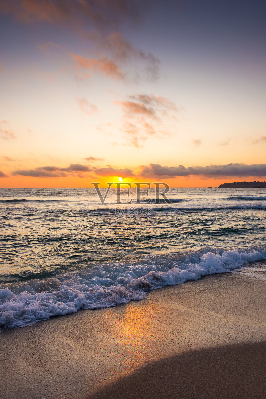 金色日出时,海浪拍打沙滩的特写照片摄影图片