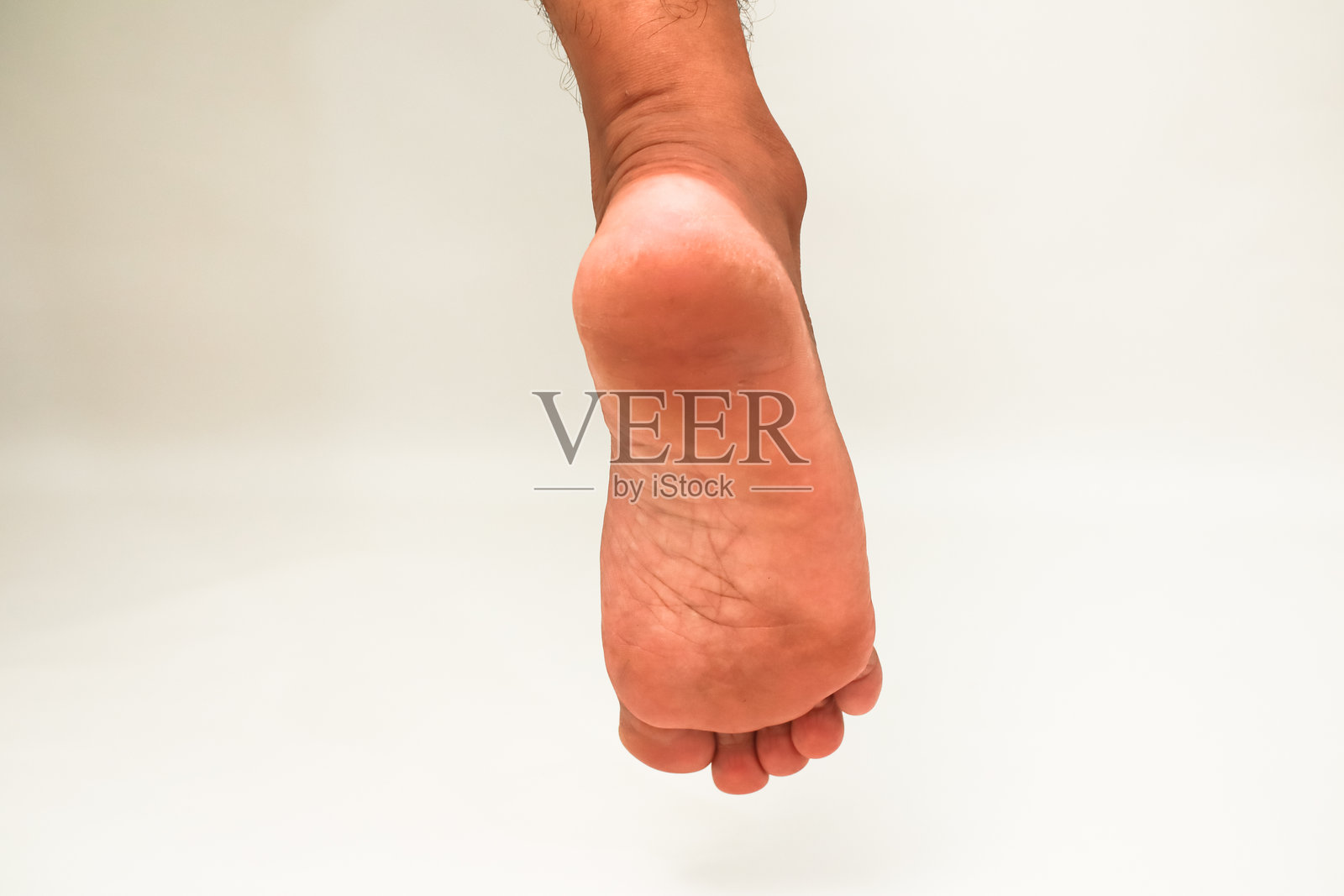 明亮灯光下,孤立的男性脚底展示出皮肤纹理和解剖结构照片摄影图片