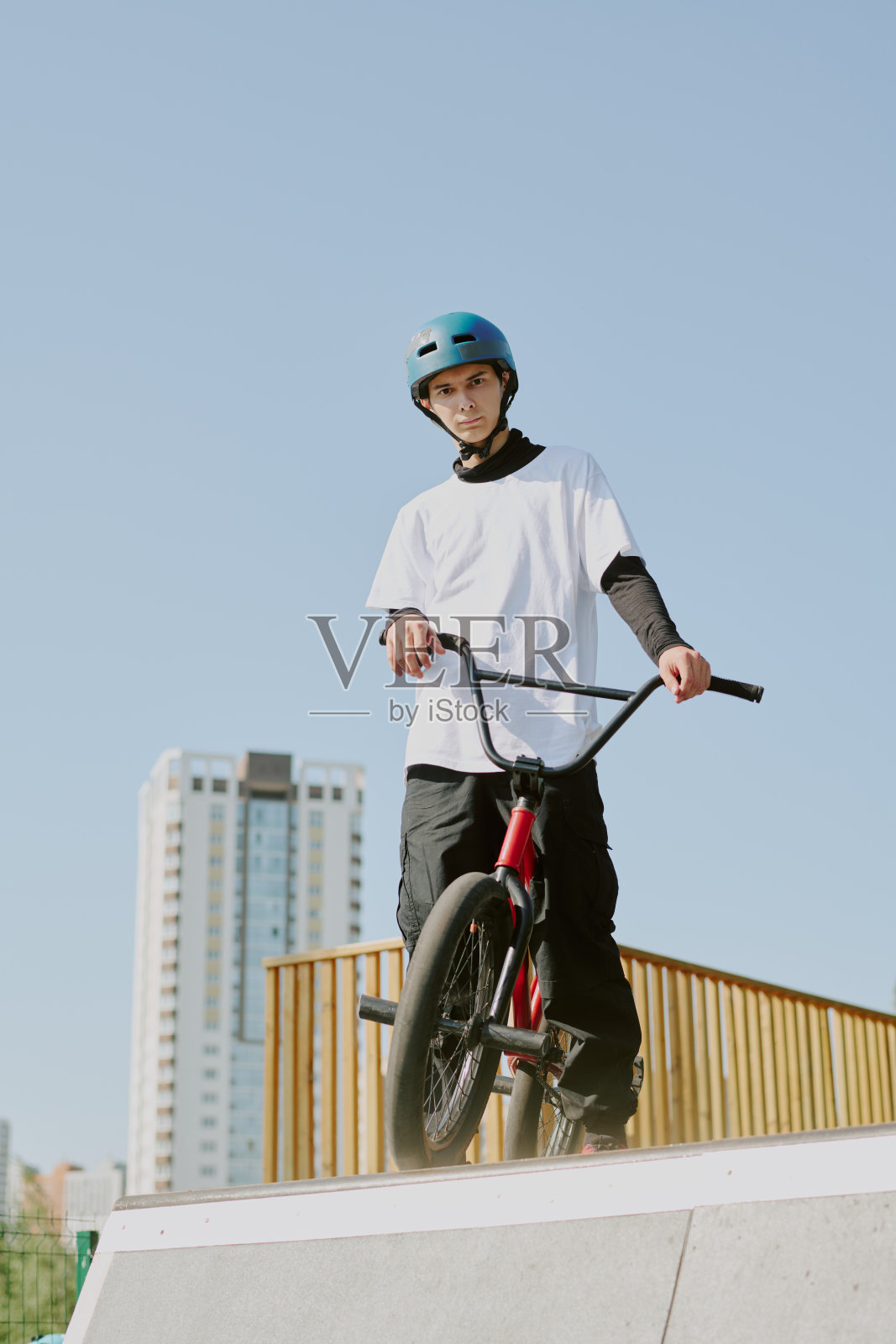 青少年在城市滑板公园户外站立,旁边放着他的BMX自行车照片摄影图片