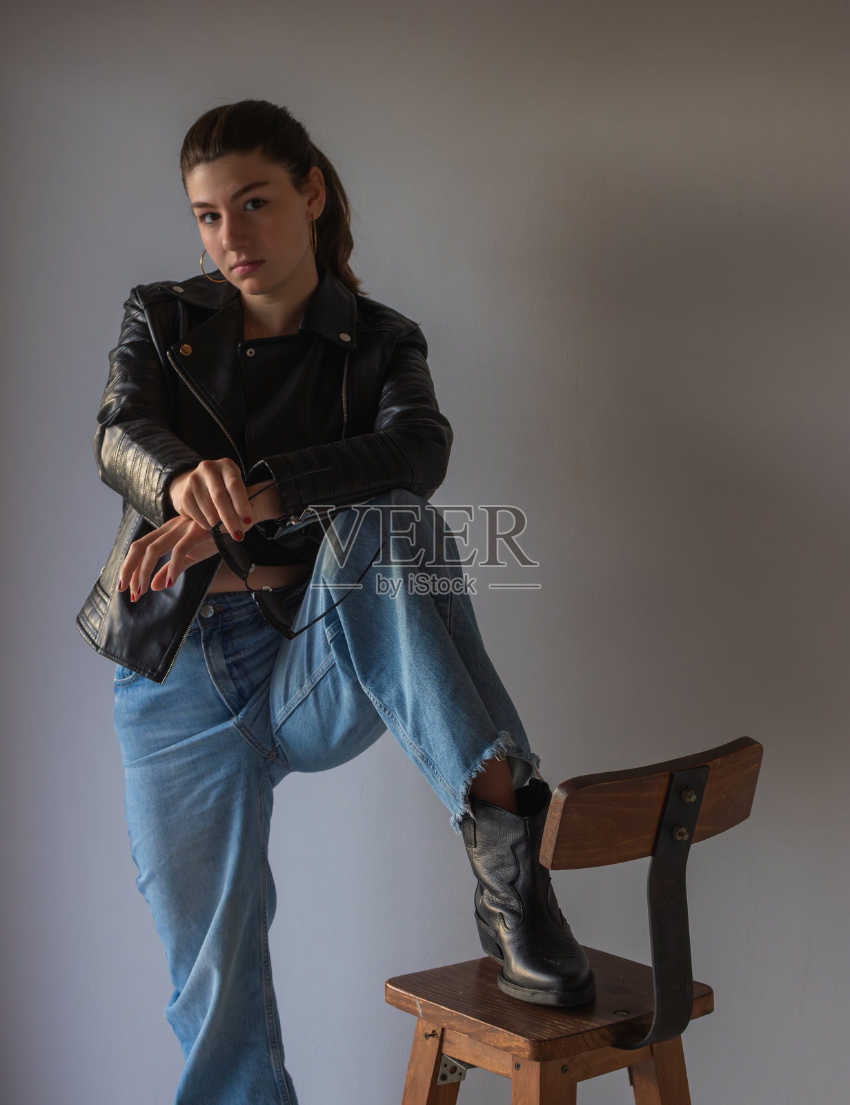 时尚金发女孩的都市肖像,身着丹宁套装,极简现代背景,竖构图实拍。照片摄影图片