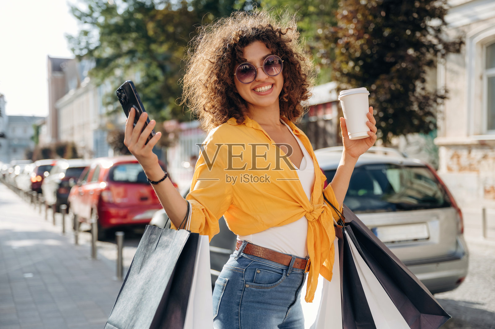 健康休闲理念。快乐的女人在城里提着购物袋照片摄影图片