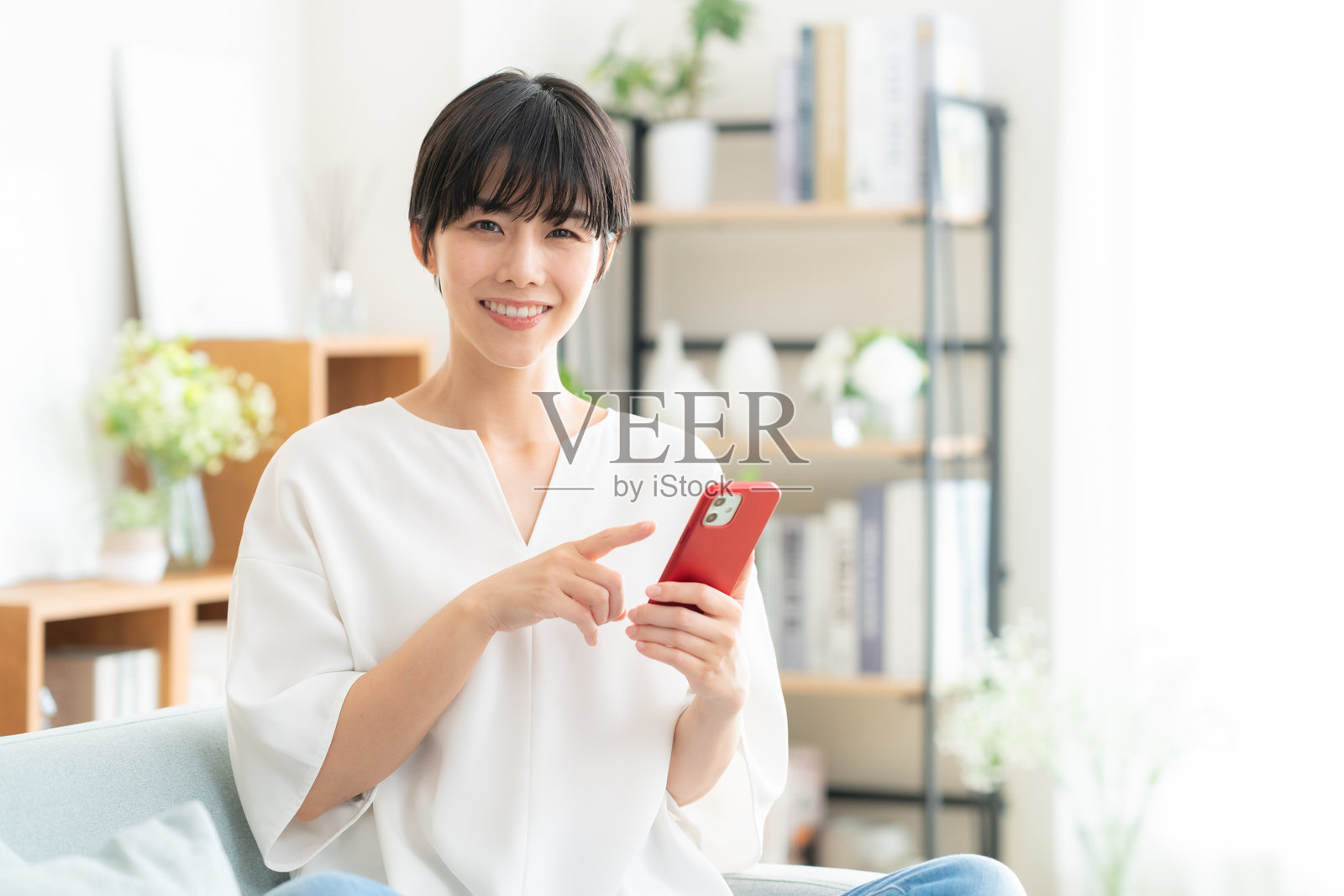 年轻女子在家中看手机照片摄影图片