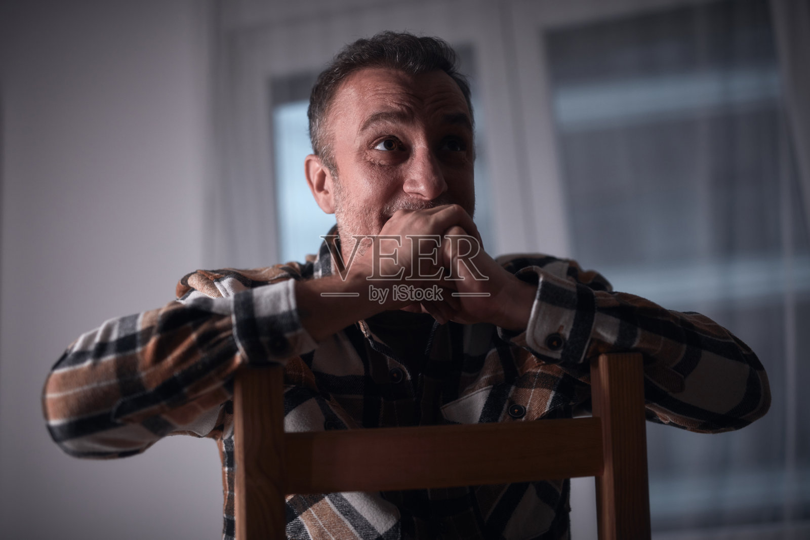 一名患有抑郁症并头痛的男子在家中坐在椅子上。照片摄影图片