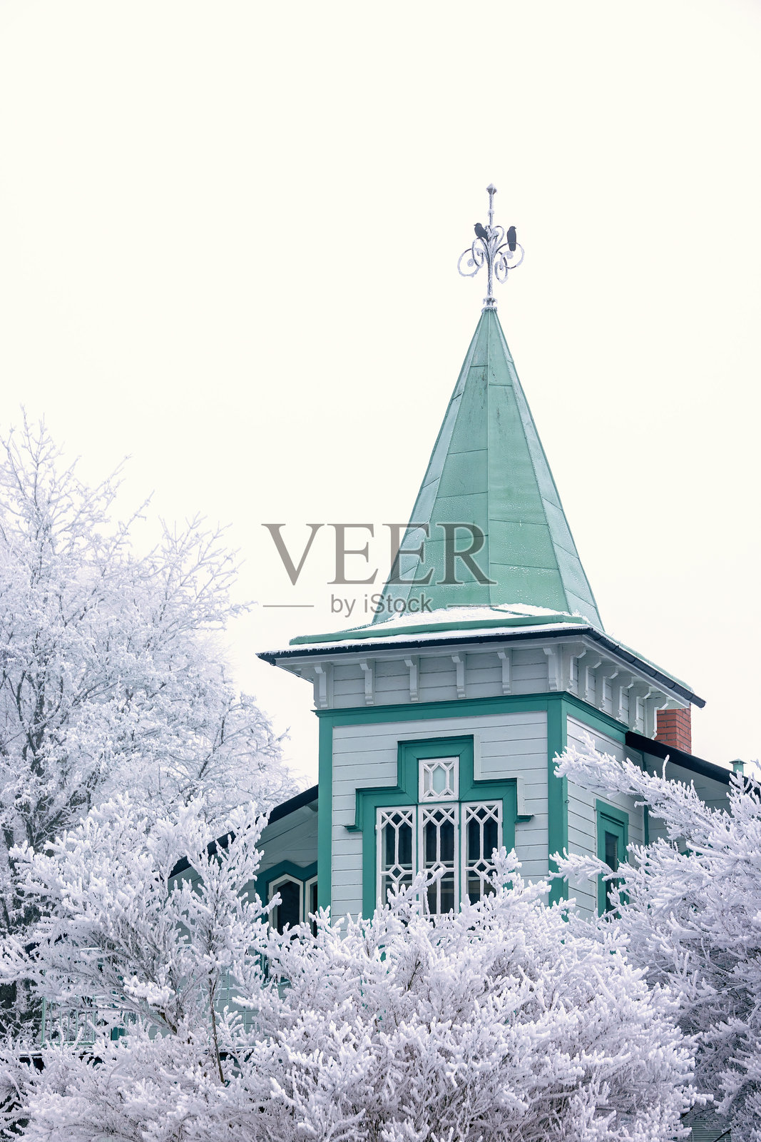 带有塔楼和冰霜树木的宁静古老木屋照片摄影图片