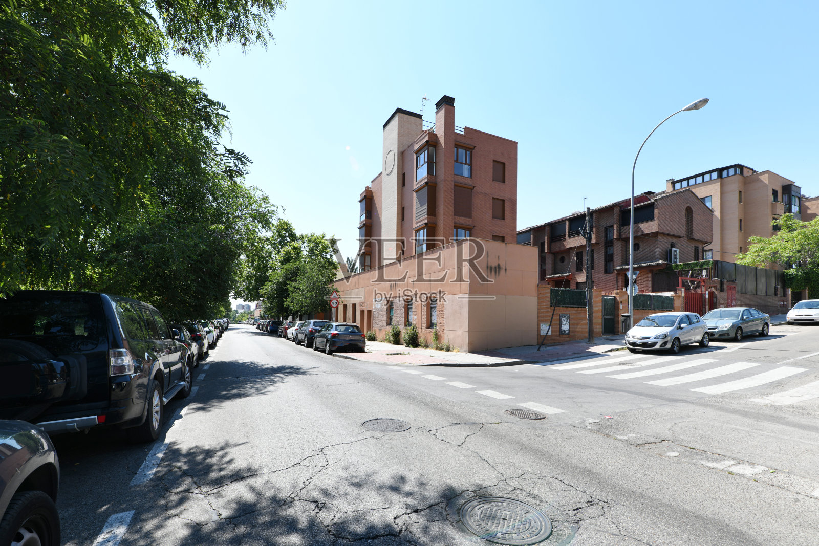 陡峭街道上的城市住宅楼外墙,设有斑马线照片摄影图片