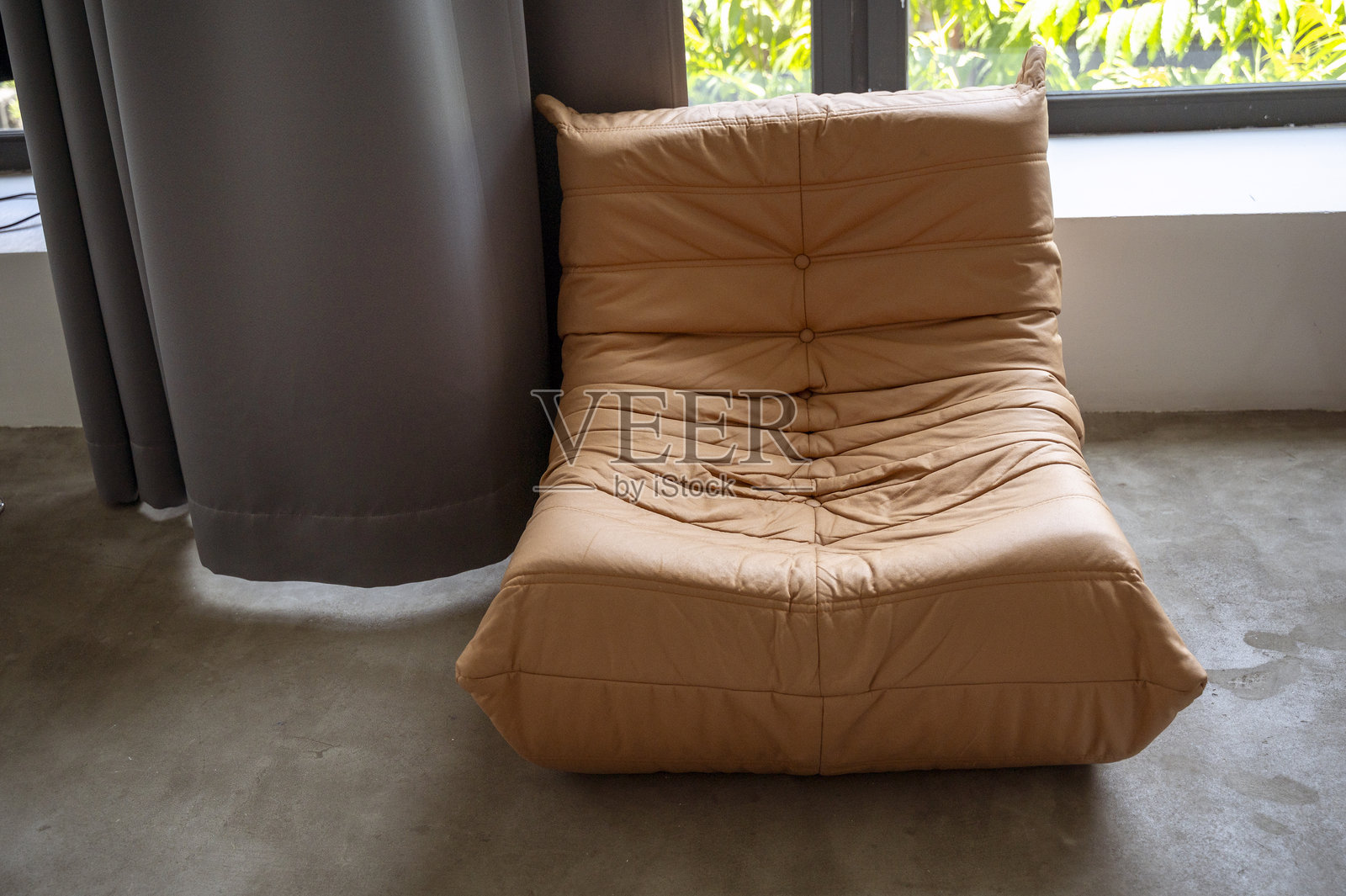 一张舒适的大号棕色扶手椅靠着大窗户的房间内部照片摄影图片