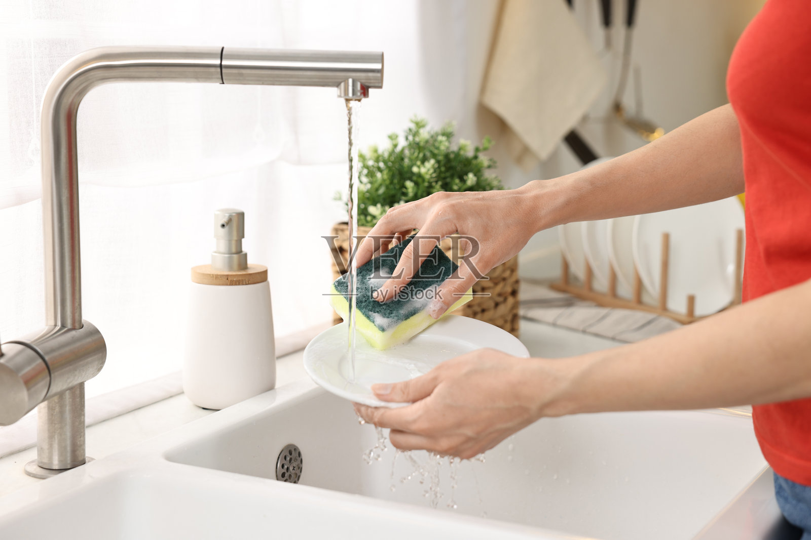 特写:女人在厨房水槽里洗碗,清洁家务照片摄影图片