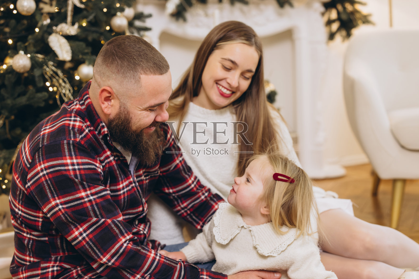 快乐的一家子在家装饰的圣诞树旁庆祝圣诞节照片摄影图片