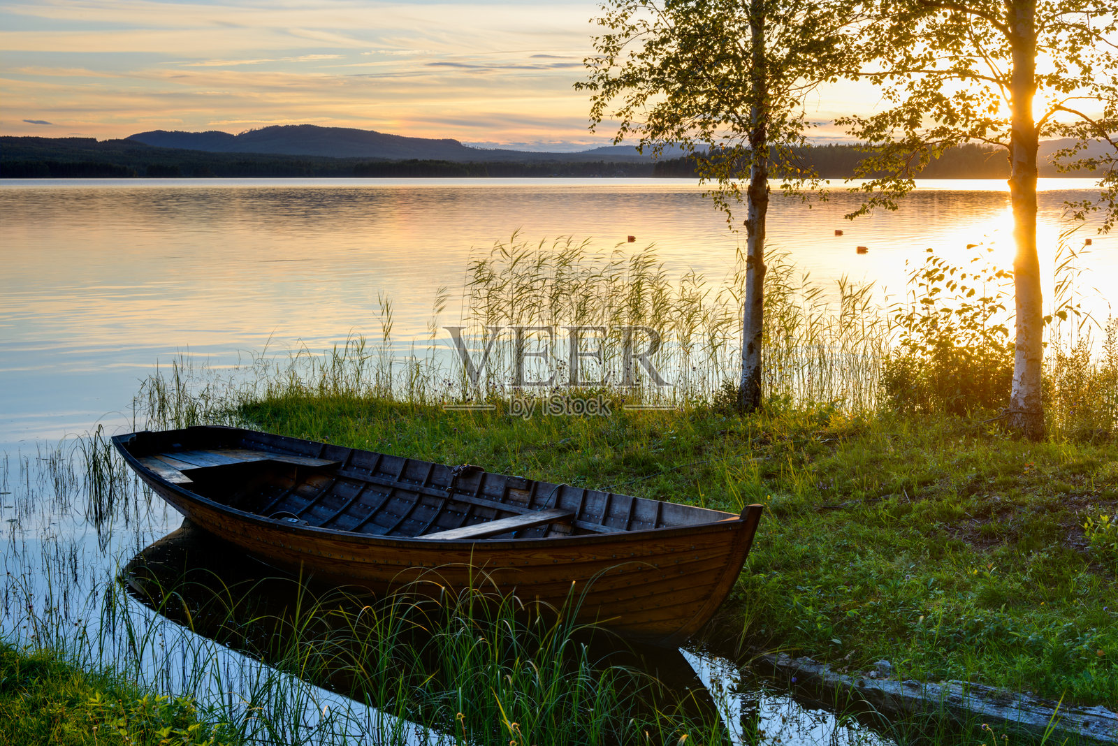 瑞典达拉那,席尔扬湖畔,夕阳下的湖边停泊的船只照片摄影图片
