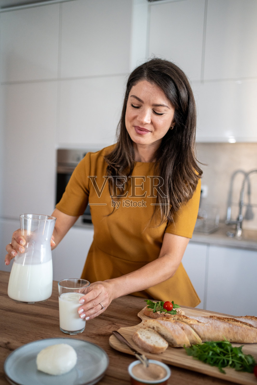 女人为健康的早餐倒牛奶照片摄影图片