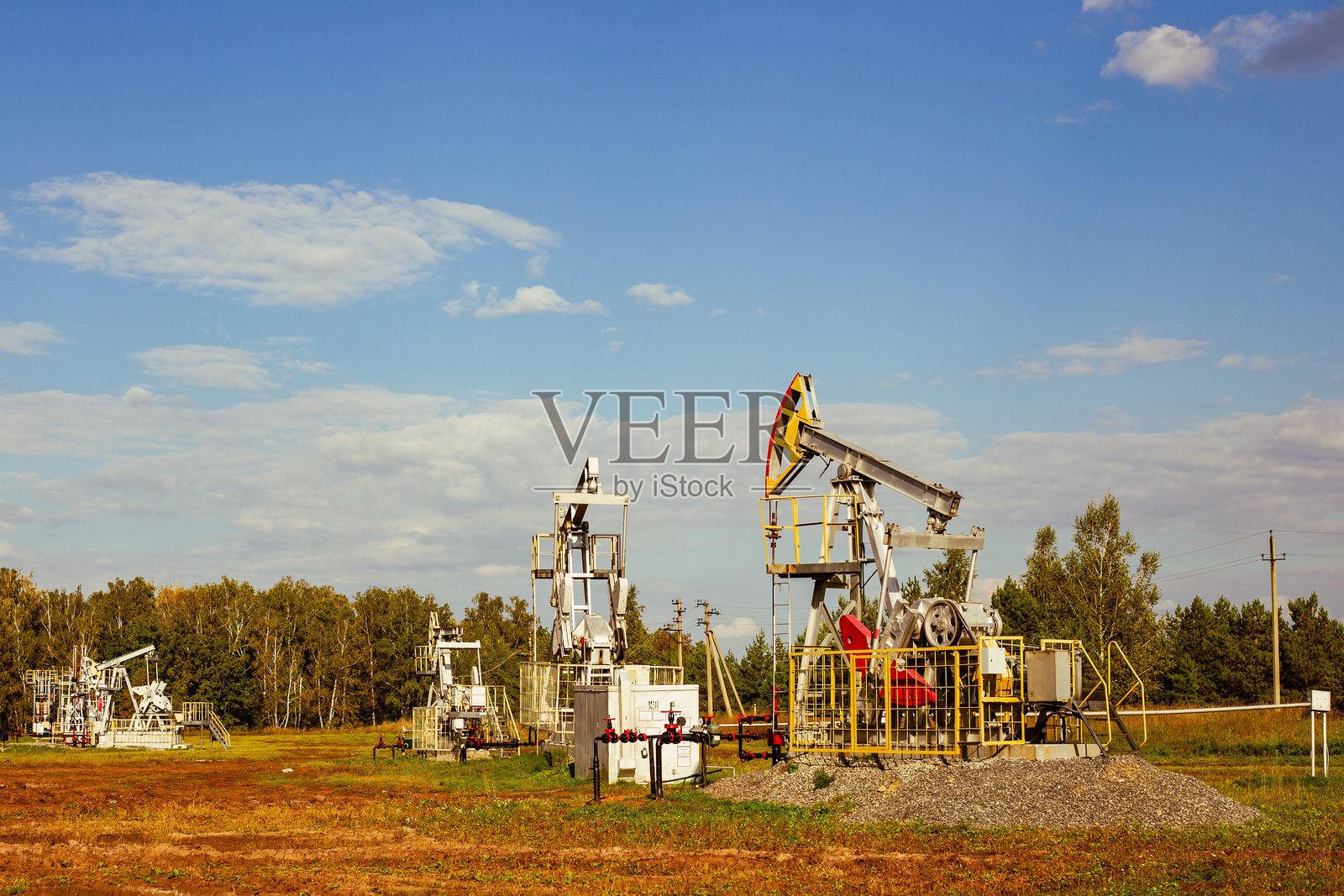 石油产业。抽油机在油田开采石油。油田照片摄影图片