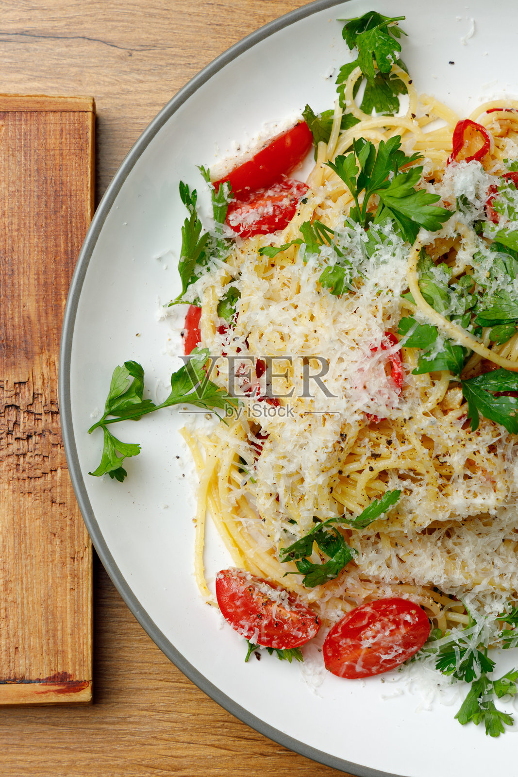 虾仁、芝麻菜和番茄意面,孤立的。女性的手拿着餐具照片摄影图片