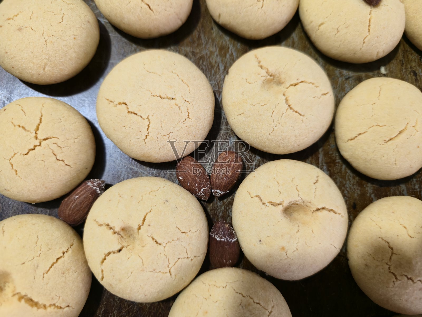 烤箱托盘上摆放着刚出炉的、撒有杏仁的印度奶酥饼干照片摄影图片